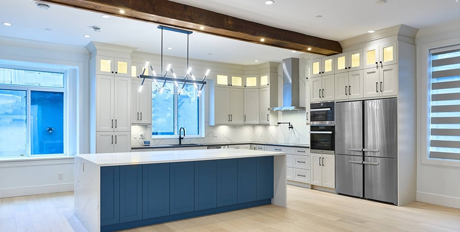 Custom kitchen with exposed wood beam and blue island