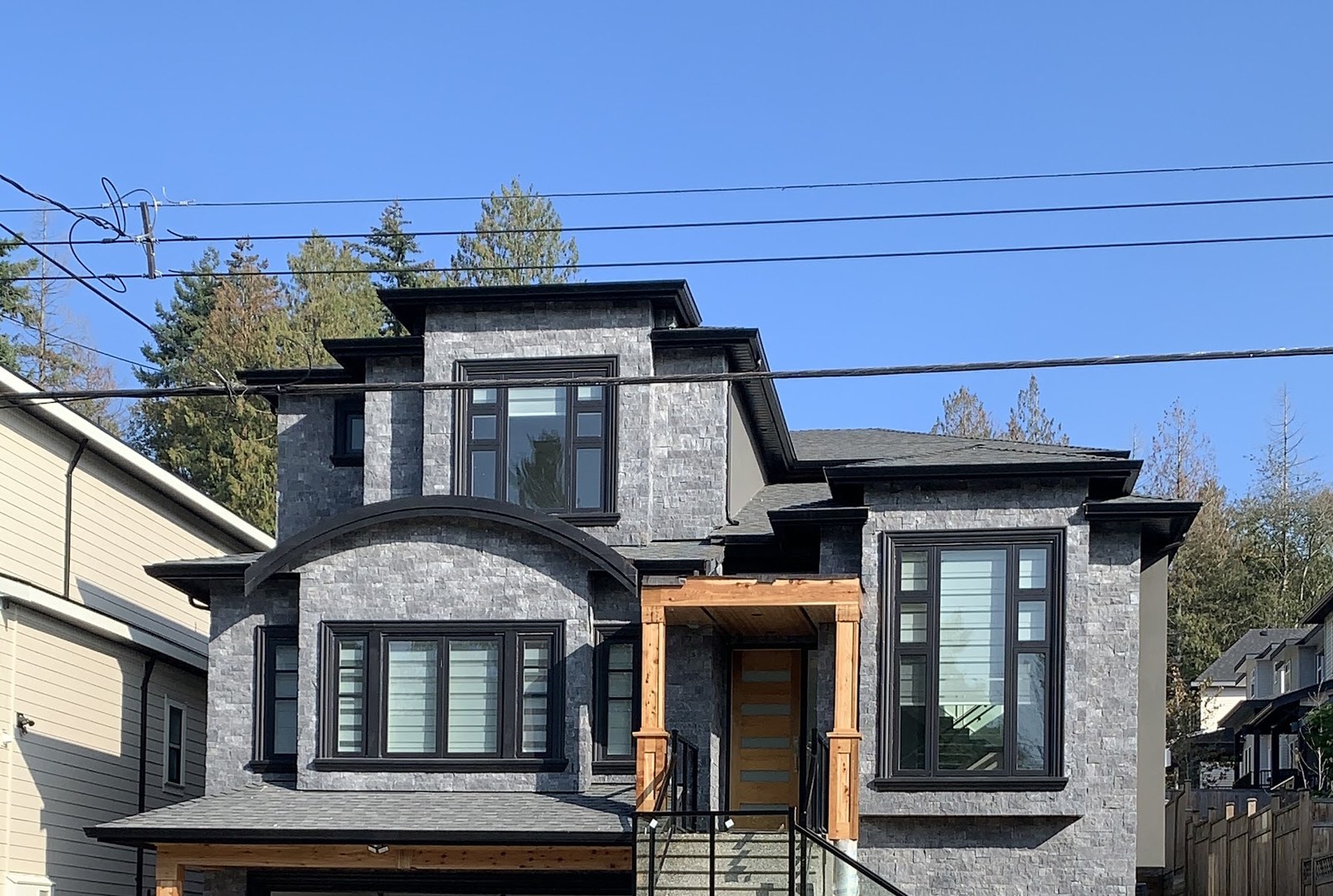Stone-clad custom home with cedar entry posts